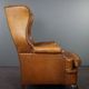 Old wingback armchair made of sheep leather in a correct condition