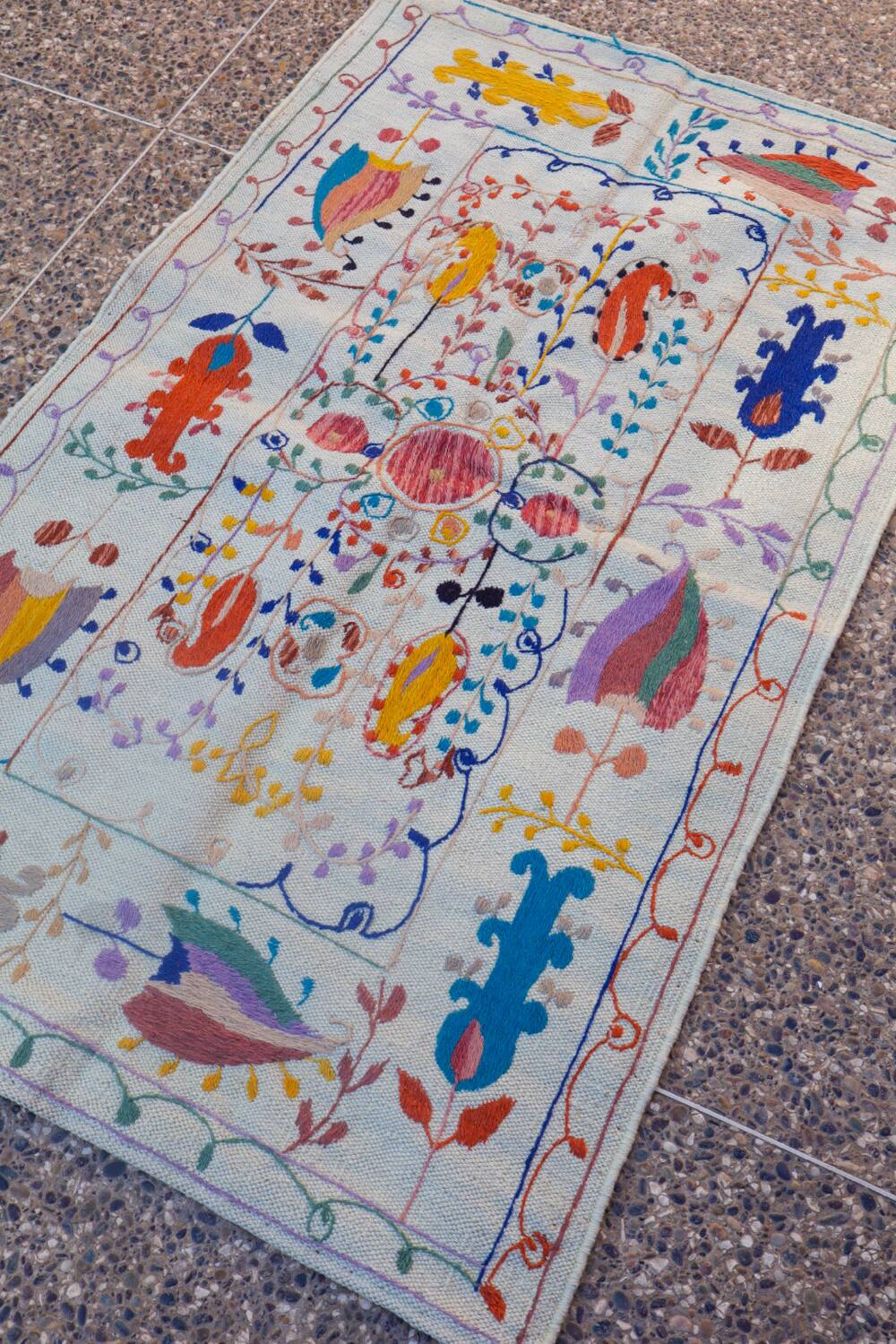 White suzani kilim rug with embroidered colorful patterns