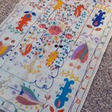 White suzani kilim rug with embroidered colorful patterns
