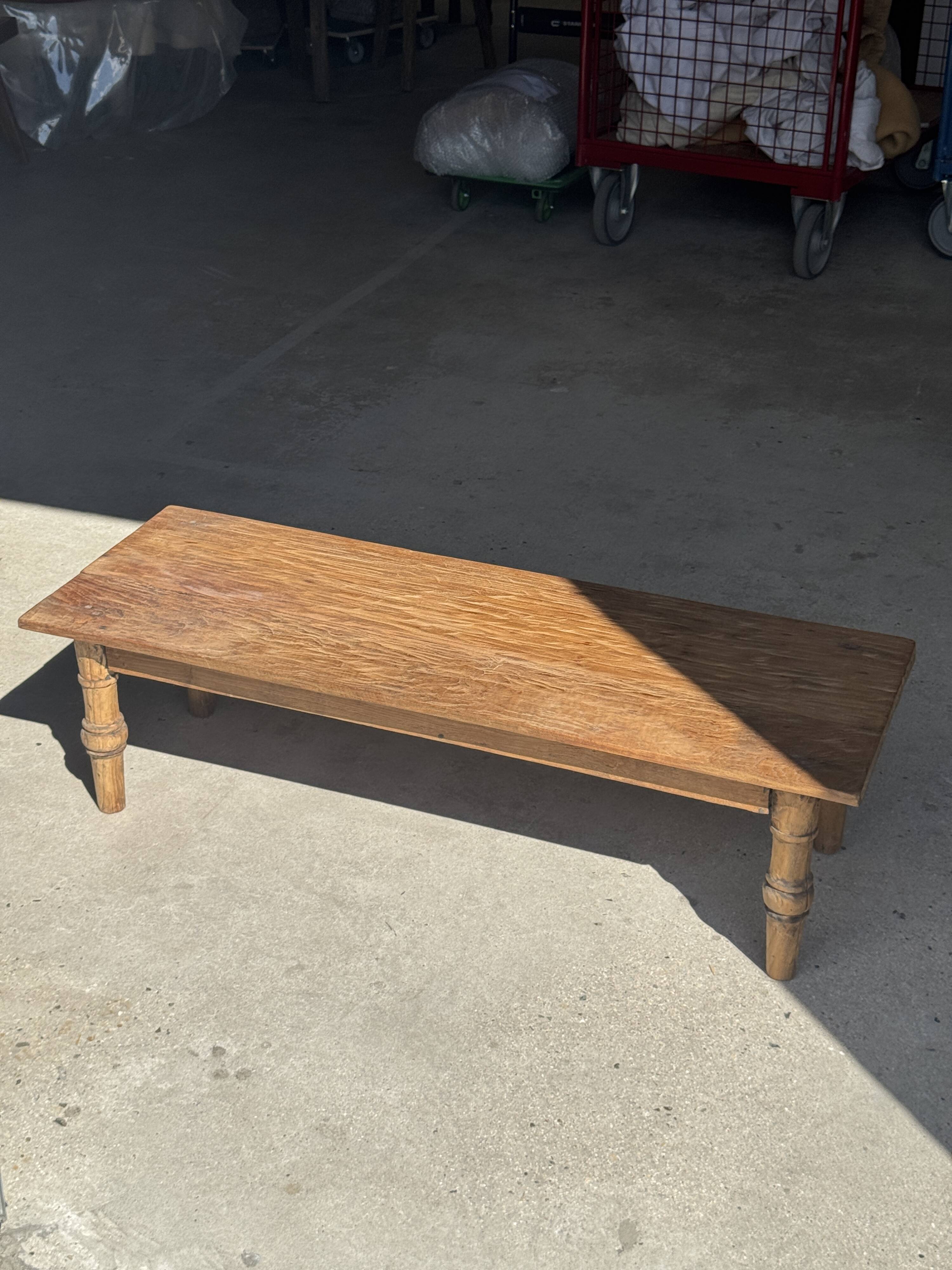 Brown Indonesian teak coffee table, with a border and cylindrical legs H40 L103.