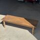 Brown Indonesian teak coffee table, with a border and cylindrical legs H40 L103.