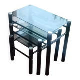 3 nesting tables in black metal with smoked glass tops.