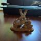 Glass table with carved wooden legs featuring intertwined fish.