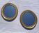 A pair of oval, gold wooden mirrors.