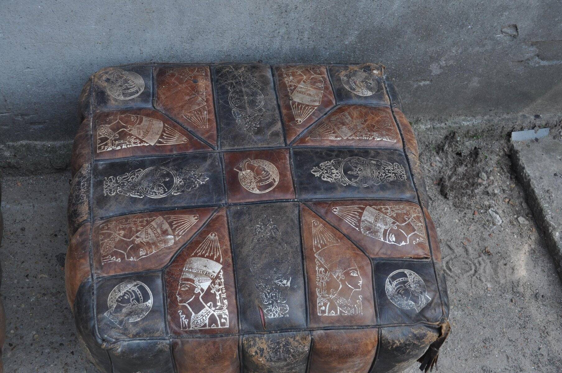 Set of 2 vintage ottomans in brown and black leather with Egyptian patterns from the 1970s.