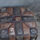Set of 2 vintage ottomans in brown and black leather with Egyptian patterns from the 1970s.