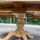 Round dining table with a central pedestal, extendable, stripped in solid walnut with 2 extensions.