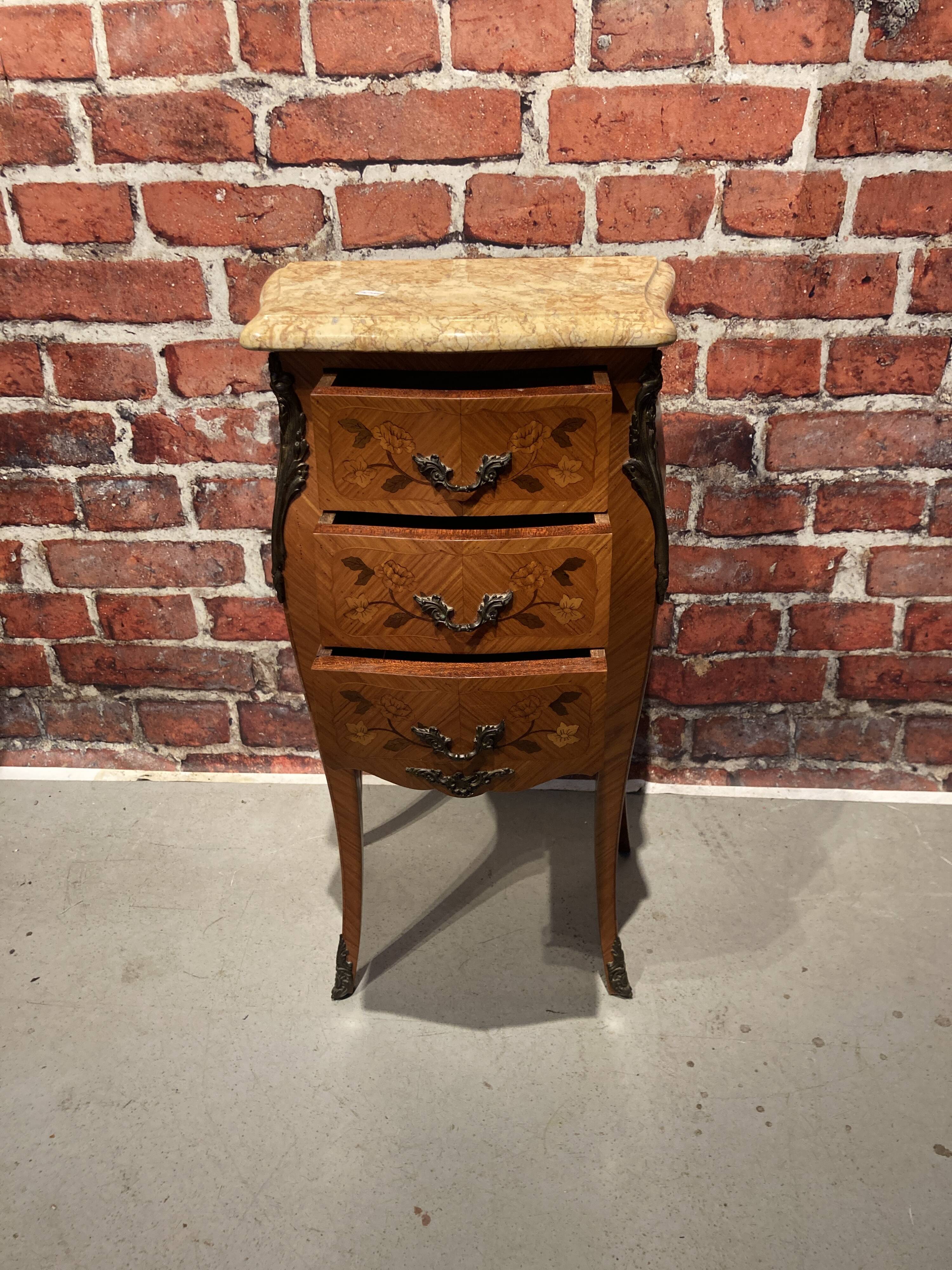 Wooden bedside table topped with a pink marble top