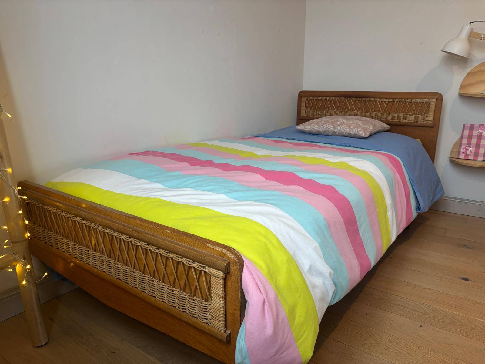 Vintage single bed made of rattan from the 1970s with a mattress.