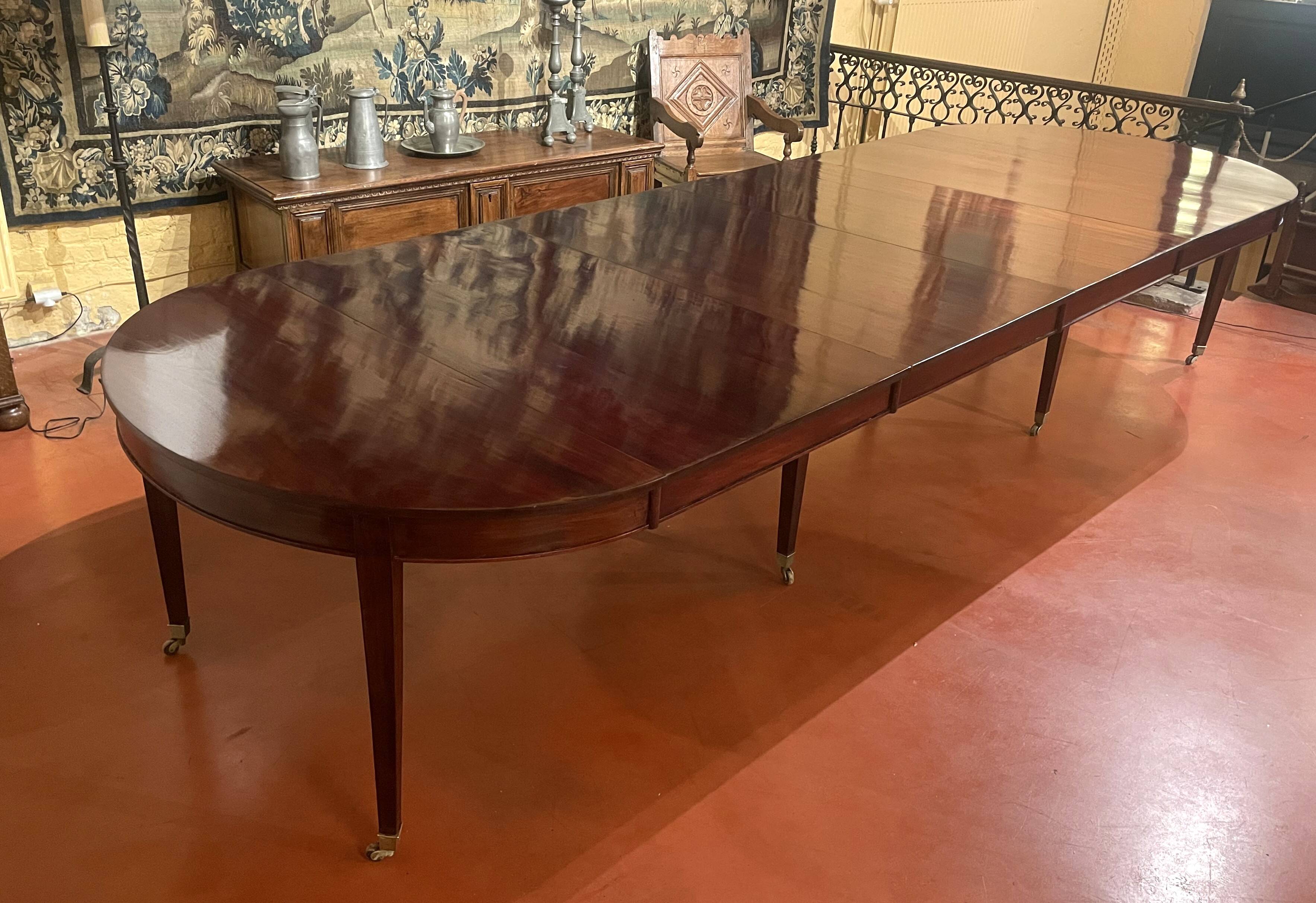 Directoire period extendable dining table in mahogany with a band.