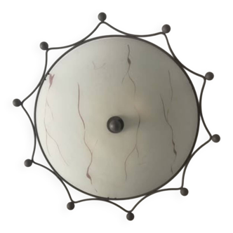 Round ceiling light with a wrought iron frame.