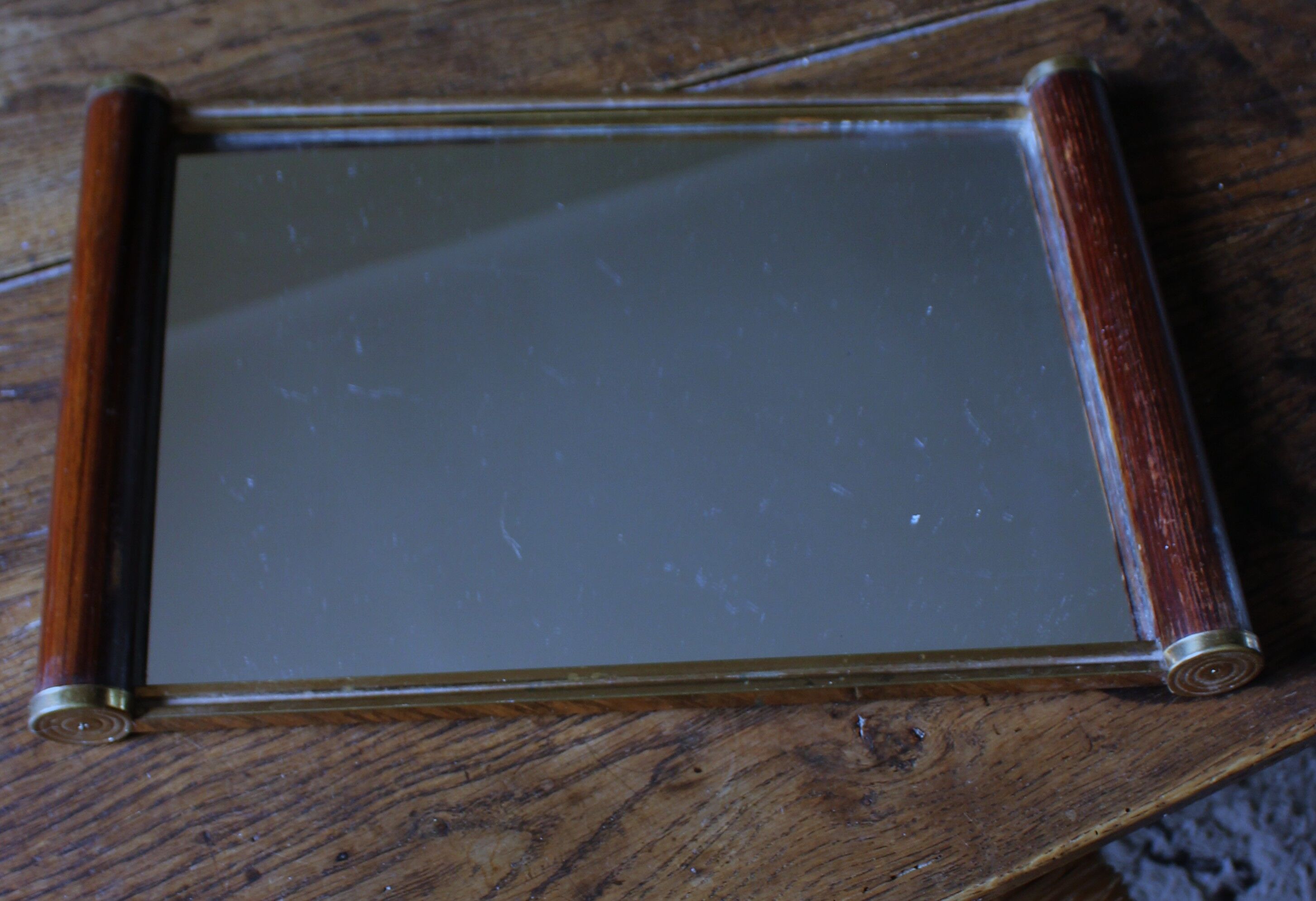Rectangular mirror tray with wooden handles and gilding.