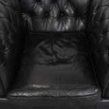 Comfortable black chesterfield armchair made of cowhide leather