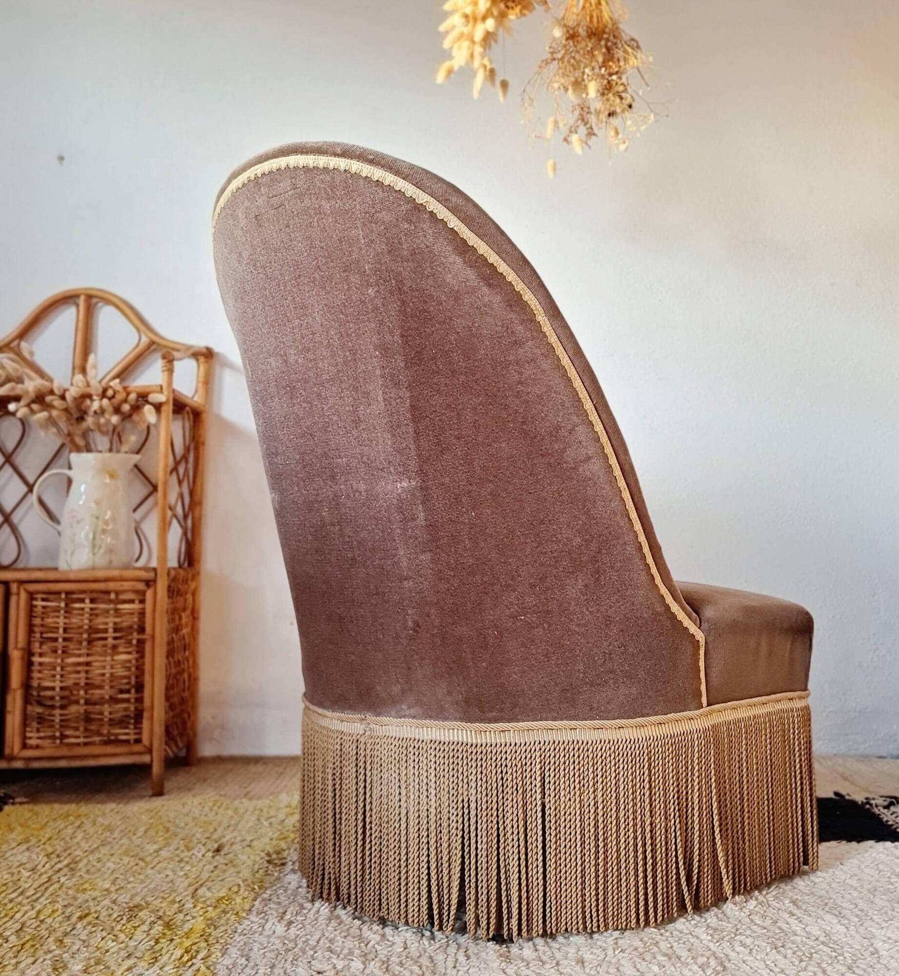 Brown velvet crapaud armchair with fringes and sculpted legs.