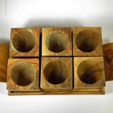 Six egg cups on a wooden tray.