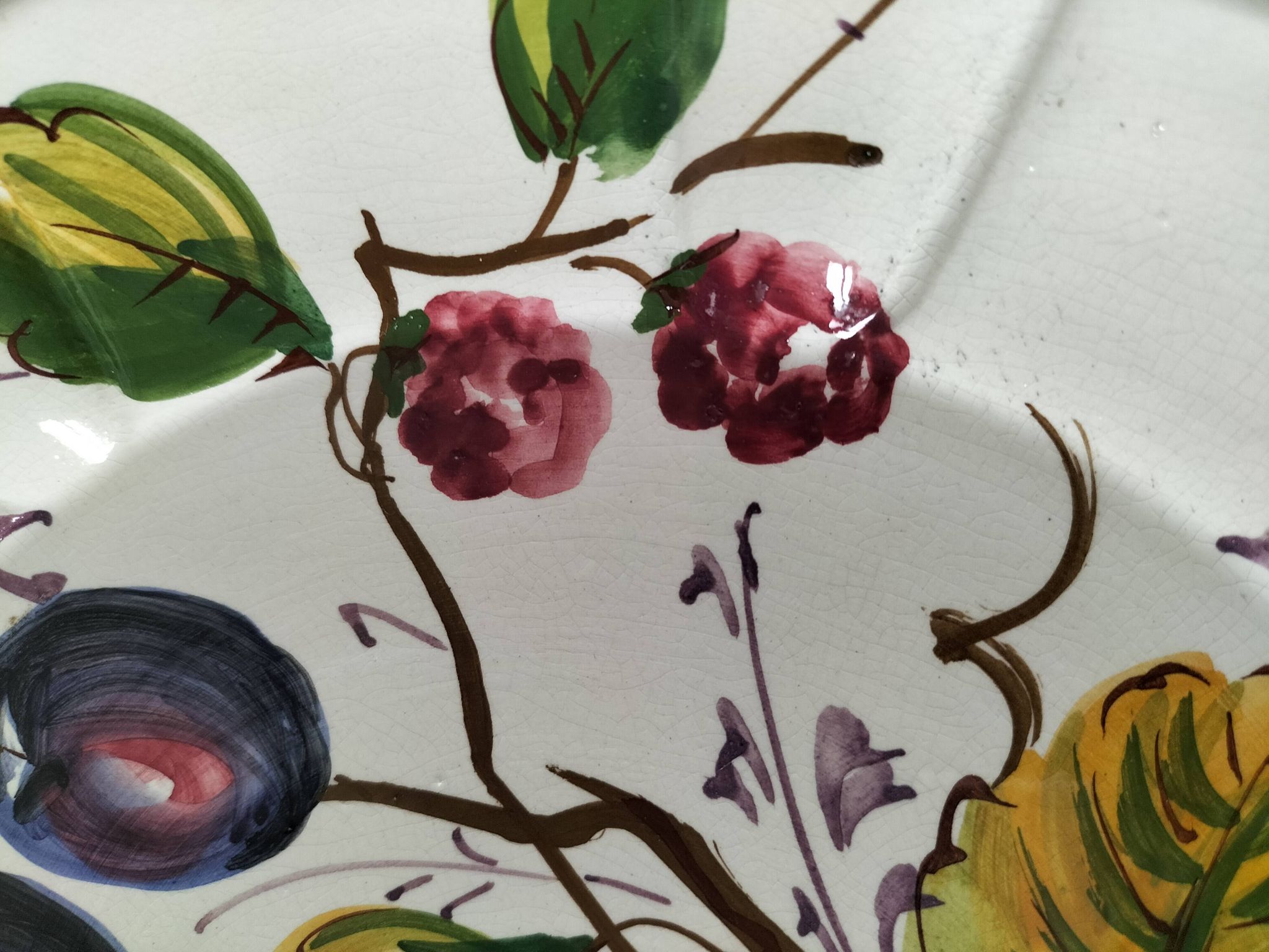 Set of three earthenware plates from Bassano, hand-painted with fruit and flower designs.