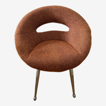 Circular armchair trimmed with orange fabric