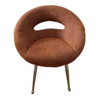 Circular armchair trimmed with orange fabric