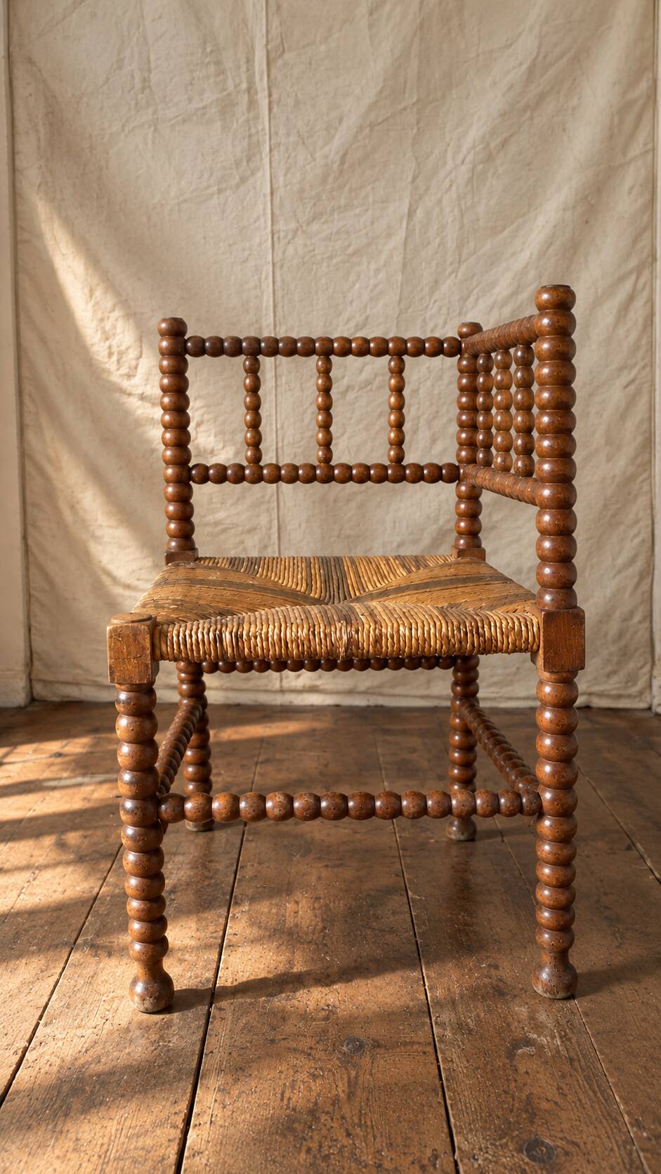 Corner chair in straw and turned wood, fireside chair.