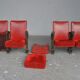 Series of 5 red skai and patinated cast Theater chairs