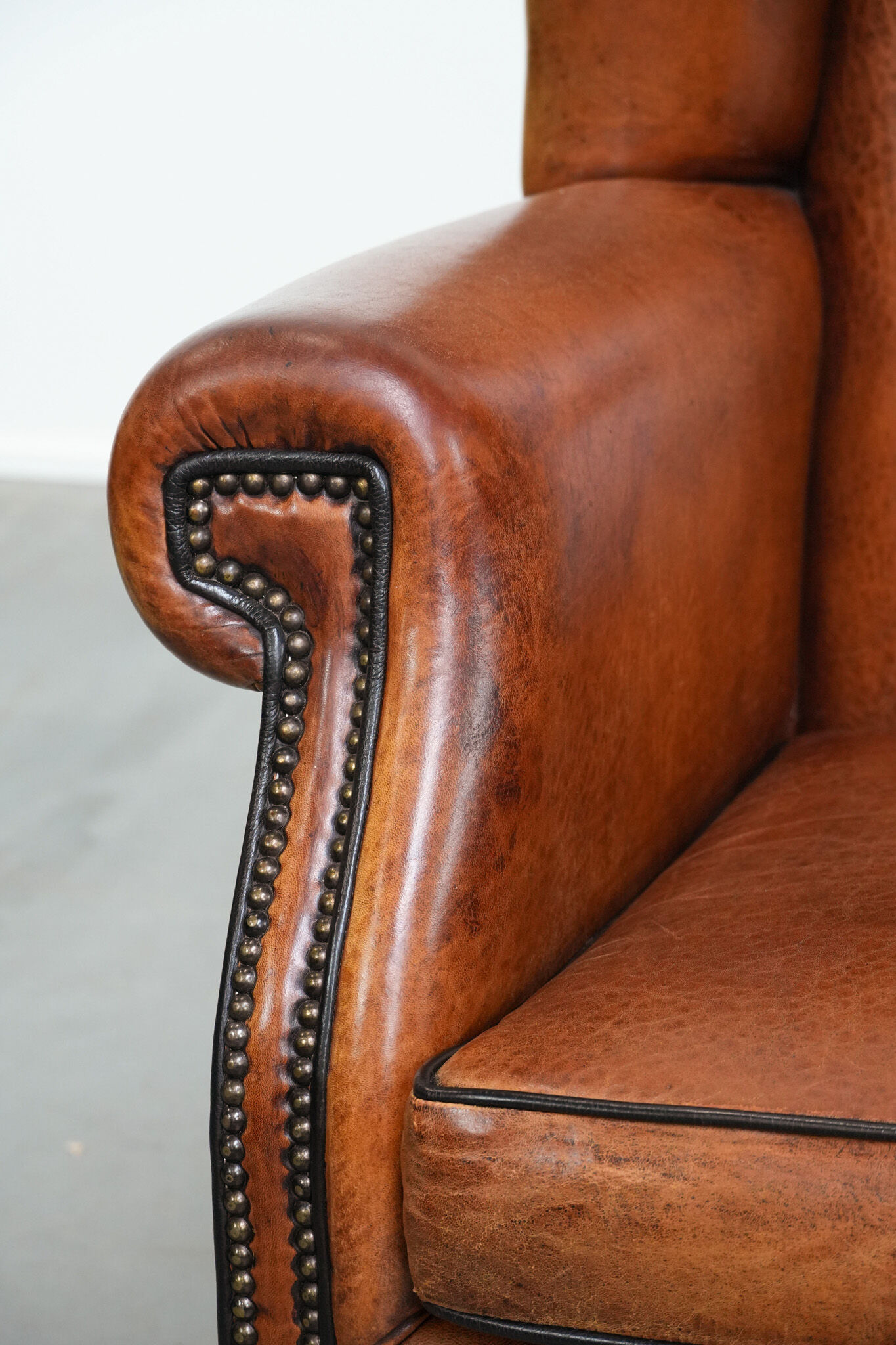Wingback chair made of sheep leather with black piping in good condition
