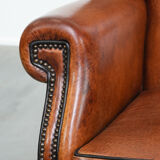 Wingback chair made of sheep leather with black piping in good condition