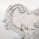 Large rococo fronton in stucco and carved wood, patinated white with an oculus.
