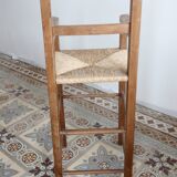 Vintage wooden high chair for children with a straw seat.