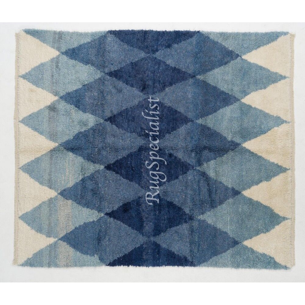 Tapis en laine contemporain avec des diamants bleus entrelacés.