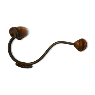 Wall-mounted coat rack with double hooks in metal and wood.