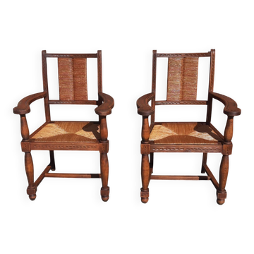 Paire de fauteuils en chêne, assises et dossiers paillés.