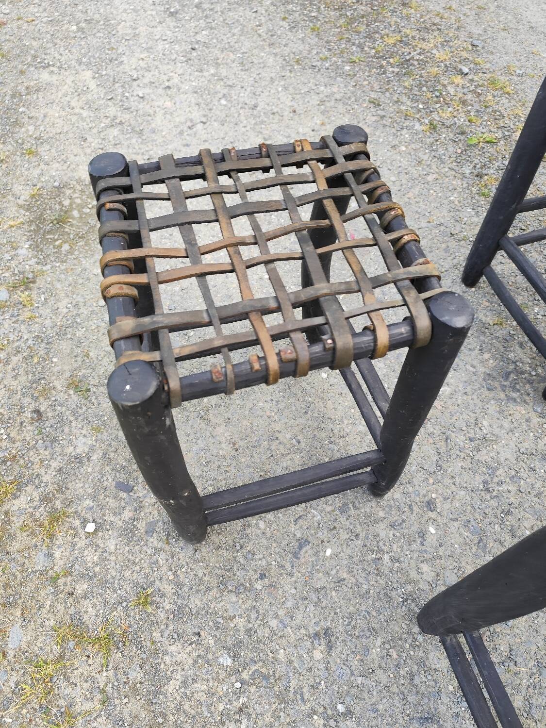 5 blackened wooden stools with woven leather seats by Nina Kaufmann