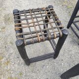 5 blackened wooden stools with woven leather seats by Nina Kaufmann