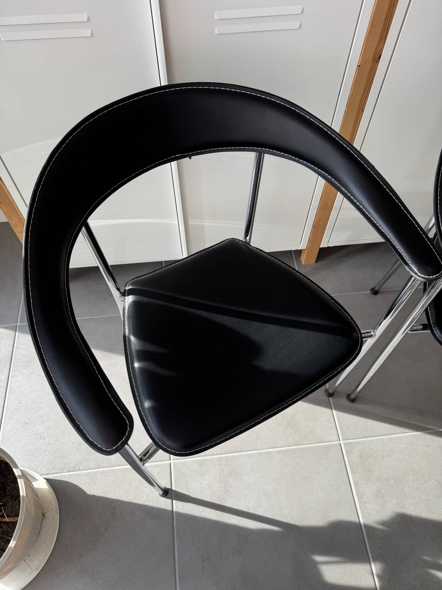 Set of two metal chairs with a brushed finish and black leather.