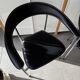 Set of two metal chairs with a brushed finish and black leather.