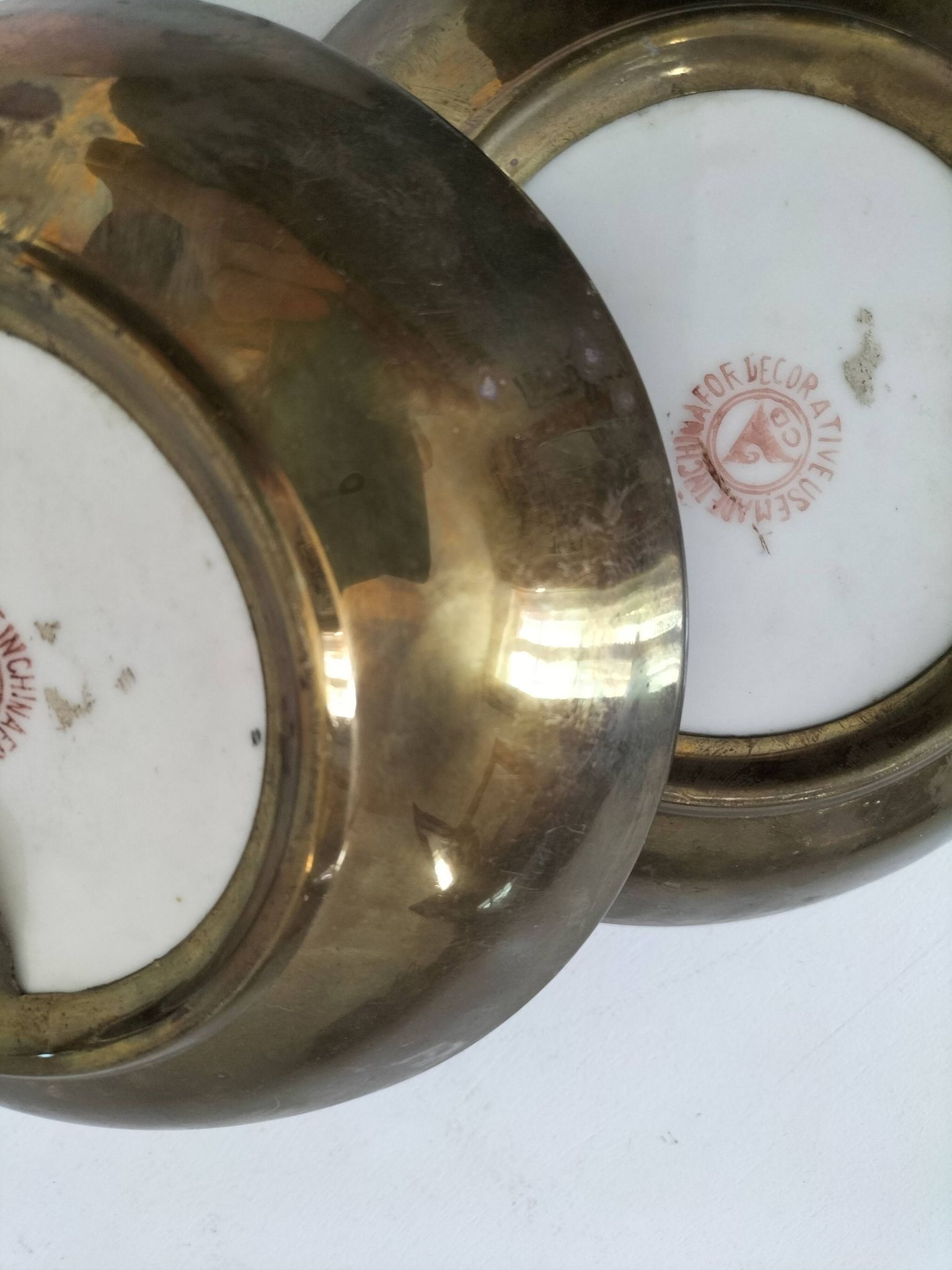 A pair of vintage Chinese decorative plates with floral designs on a yellow background.