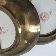 A pair of vintage Chinese decorative plates with floral designs on a yellow background.