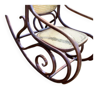 Thonet rocking chair in curved brown wood, period seat, 19th-century bentwood style.