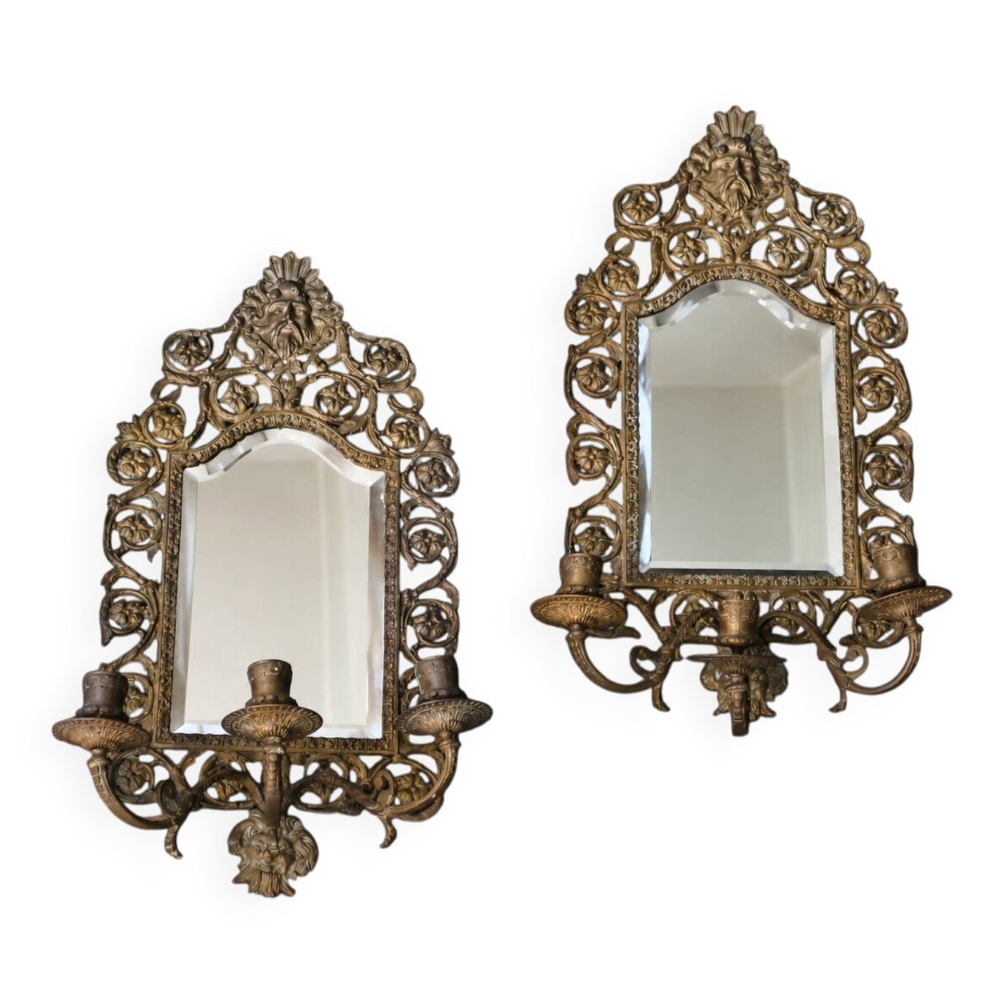 Pair of mirror wall sconces with brass candle holders.