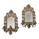 Pair of mirror wall sconces with brass candle holders.