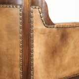 Antique armchair made of sheepskin and wood with decorative nails