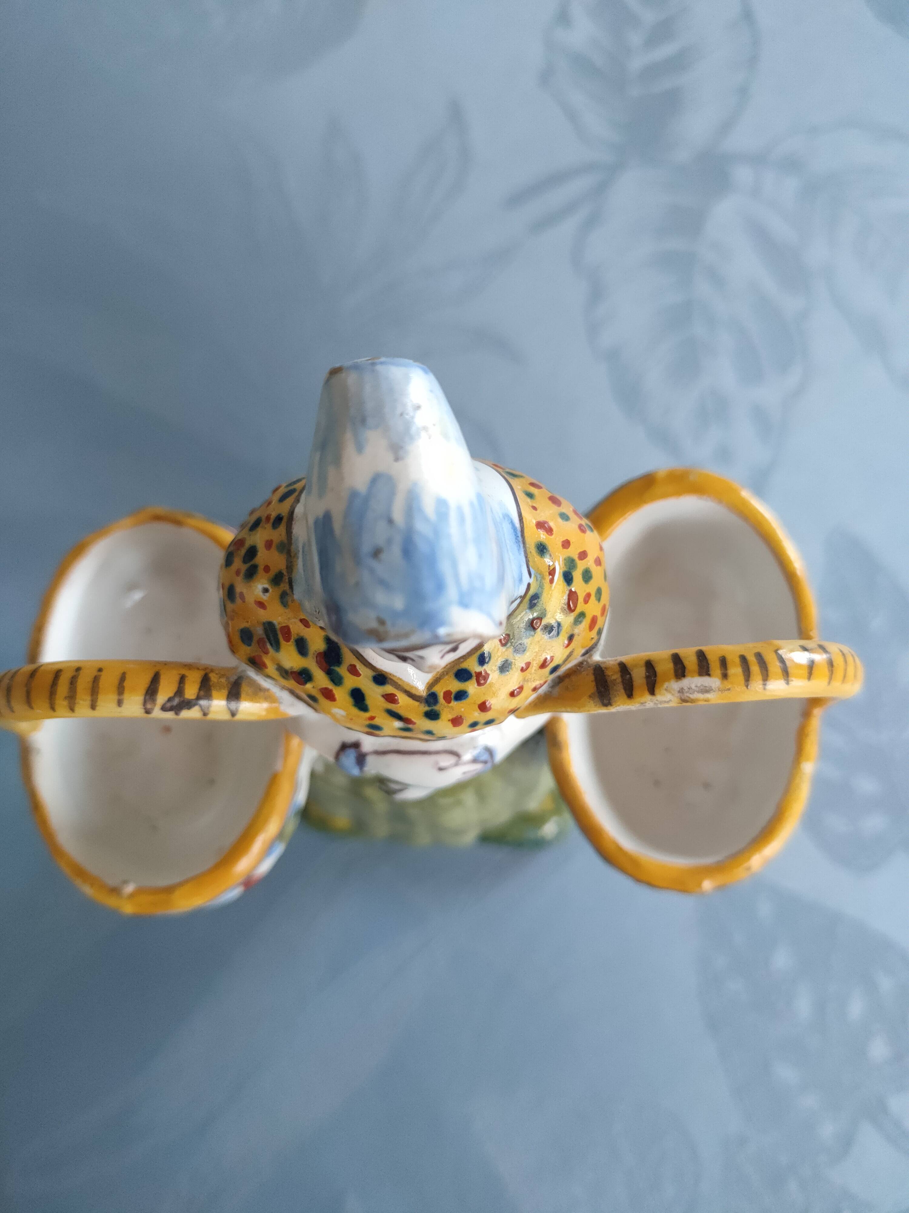 Antique earthenware salt cellar with a woman with baskets