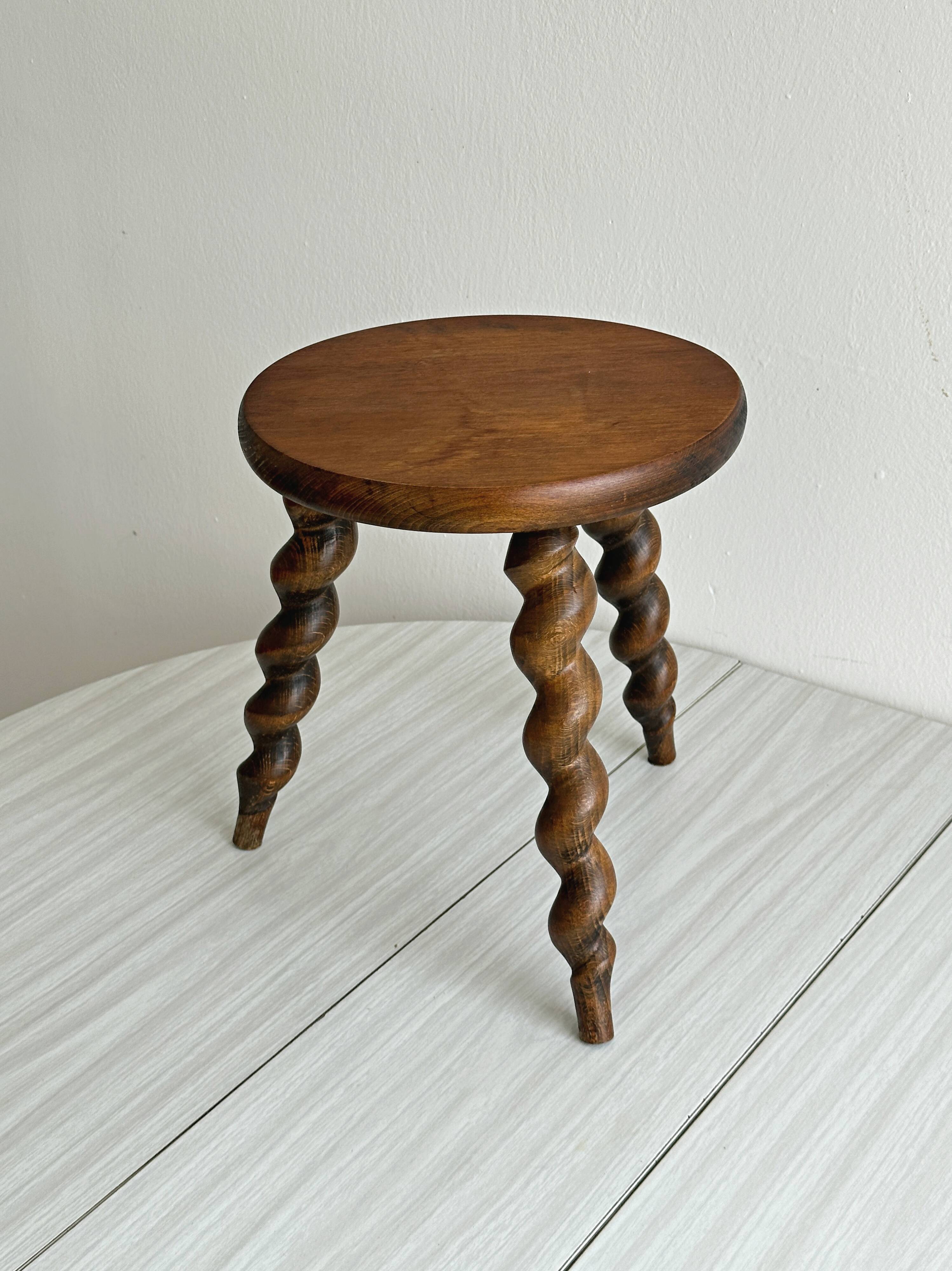 Small antique tripod stool in dark wood.