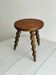 Small antique tripod stool in dark wood.