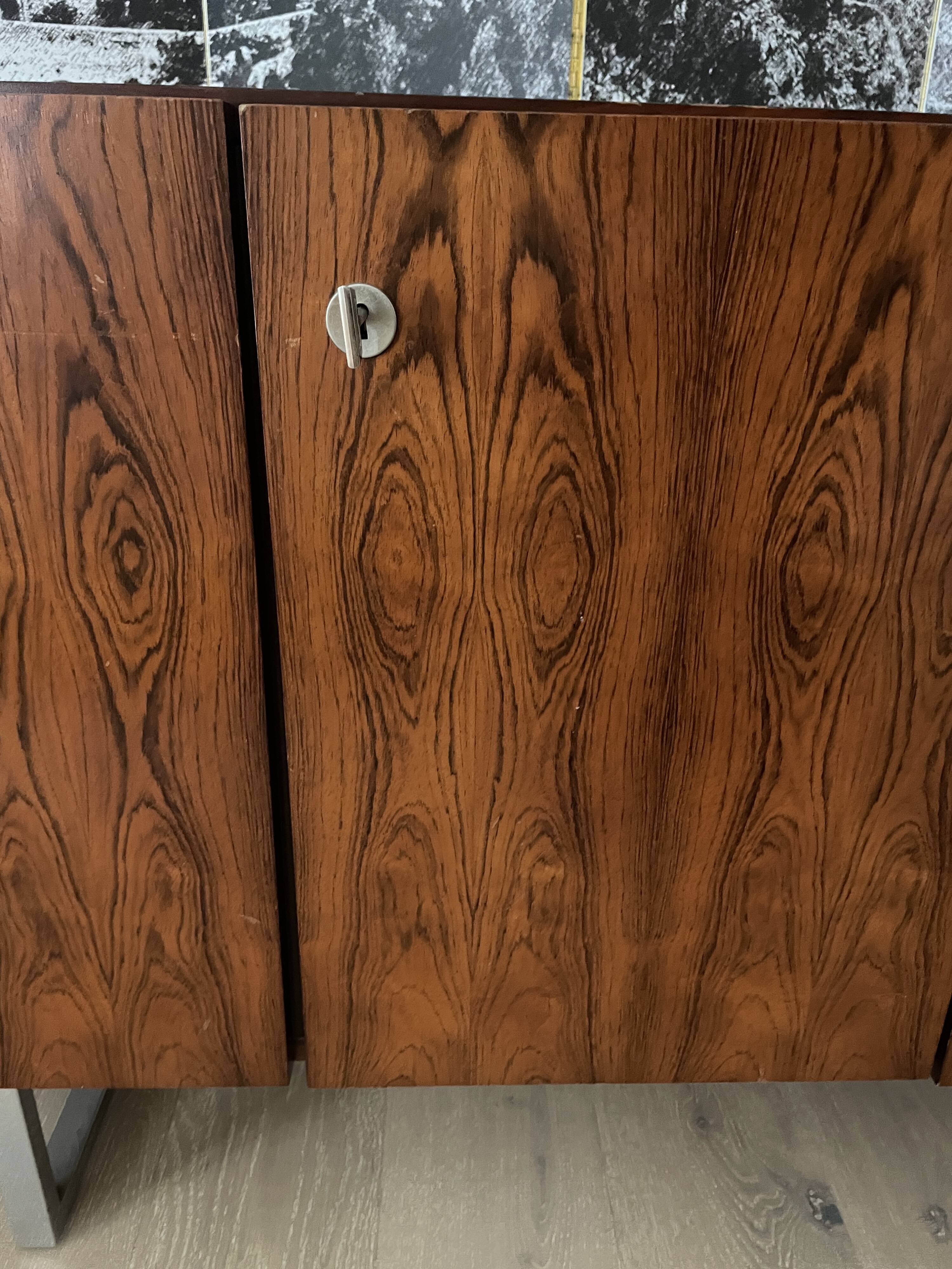 Enfilade scandinave en palissandre, 5 portes. Piétement en tube carré chromé.