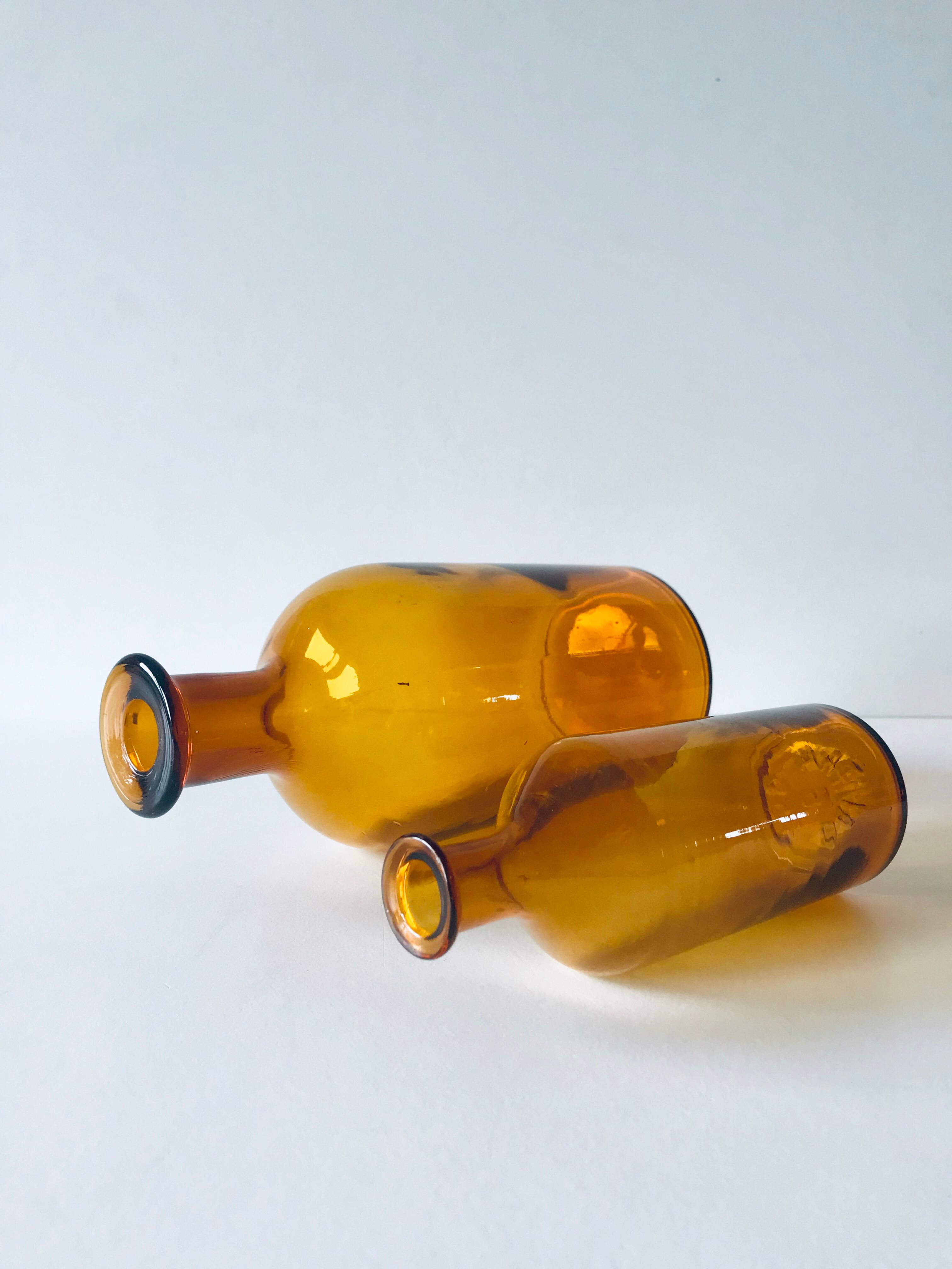 Duo of ancient apothecary flakes in amber glass