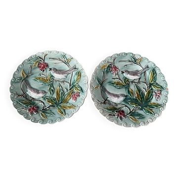Duo d'assiettes en barbotine a decor de deux oiseaux sur un arbre fruitier