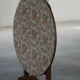 19th-century French round wine table with an adjustable top and floral textile surface.