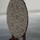 19th-century French round wine table with an adjustable top and floral textile surface.