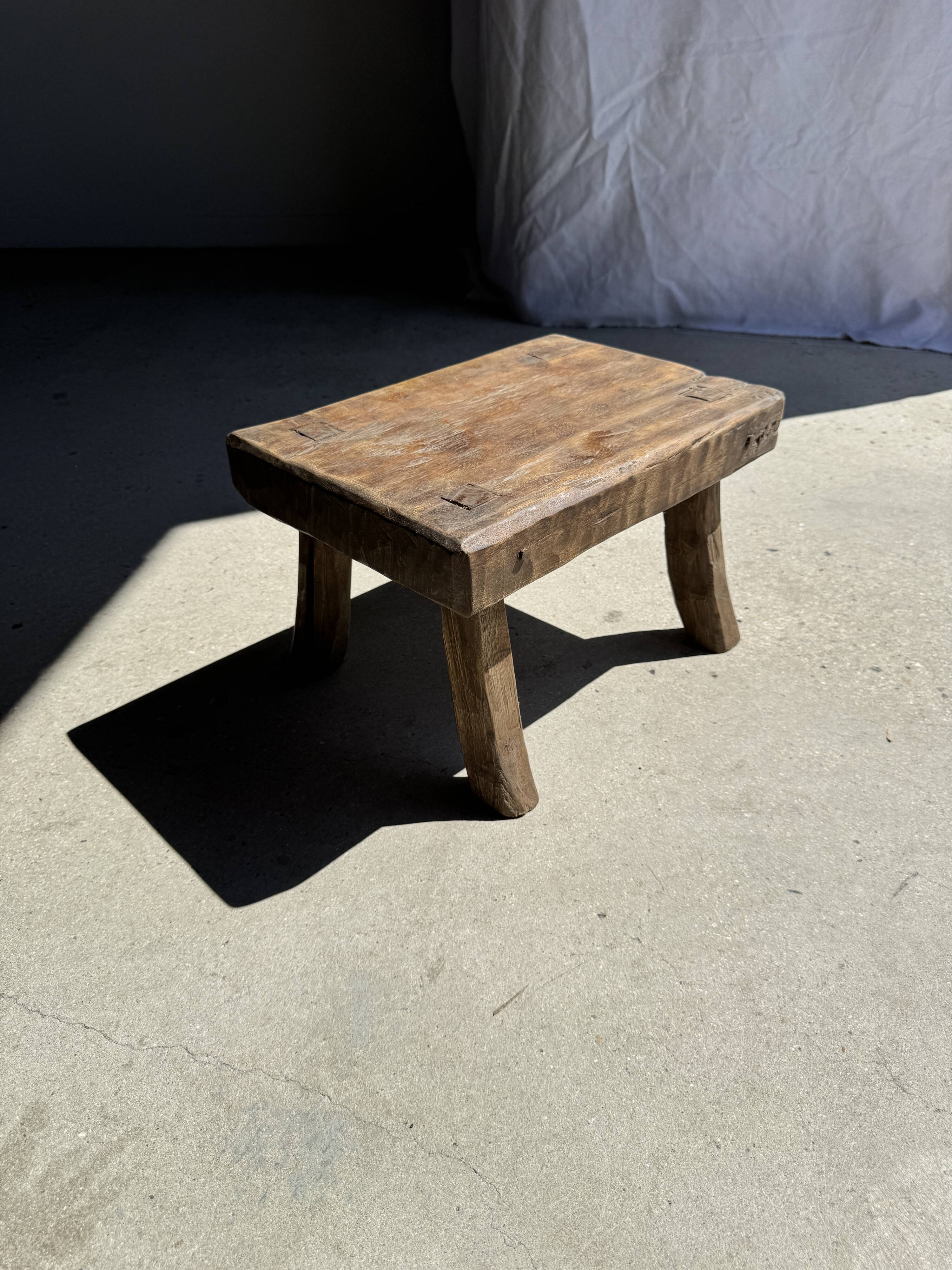 Small stool, rectangular solid teak side table with curved legs.